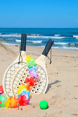 rackets and necklace on the shore