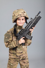 Young boy dressed like a soldier with rifle