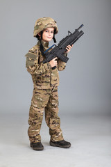 Young boy dressed like a soldier with rifle