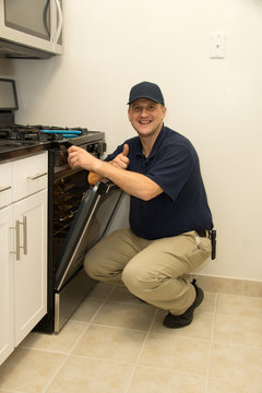 Handyman repairs oven