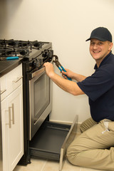 Handyman repairs oven