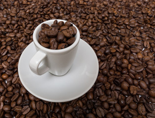 Cup with coffee beans on the background of the coffee beans
