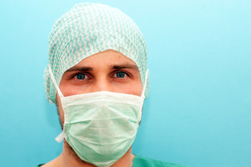 Junger Arzt Chirurg Orthopäde mit Mundschutz und Haube nach der Operation 