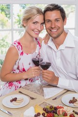 Loving young couple with wine glasses at dining table