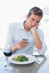 Man text messaging at food table