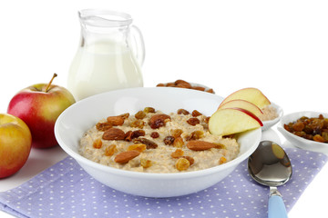 Tasty oatmeal with raisins and apples isolated on white