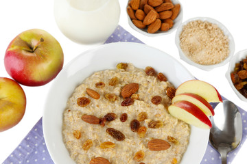 Tasty oatmeal with raisins and apples close up