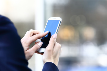 Close up of a business woman using mobile smart phone