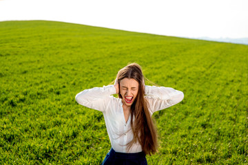 Lonely girl crying in the green field with cloudy sky
