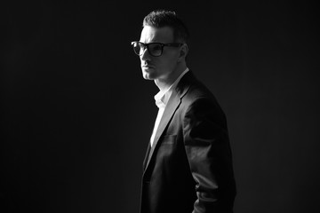 Fototapeta na wymiar Black and white photo of a thoughtful businessman in glasses