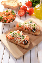 Delicious bruschetta with tomatoes on cutting board close-up
