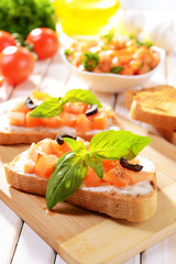 Delicious bruschetta with tomatoes on cutting board close-up