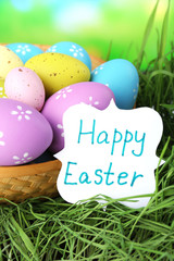Easter composition with eggs on green grass, on blue background