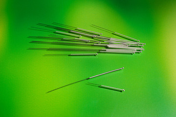 Needles for acupuncture on green background