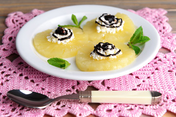 Tasty pineapple with cottage cheese on  wooden table