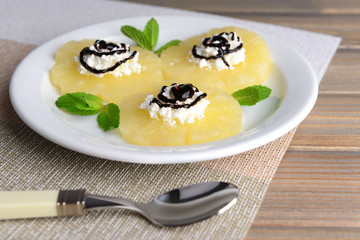 Tasty pineapple with cottage cheese on  wooden table