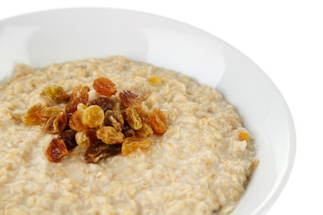 Tasty oatmeal with raisins close up