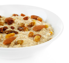 Tasty oatmeal with raisins isolated on white