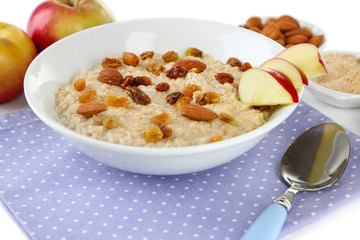 Tasty oatmeal with raisins and apples close up