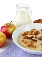 Tasty oatmeal with raisins and apples isolated on white