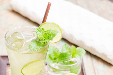 Iced green tea with lime garnish and ice cube