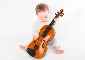 Beautiful baby girl playing with a violin