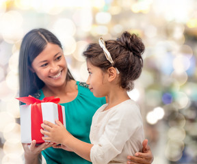 happy mother and child girl with gift box