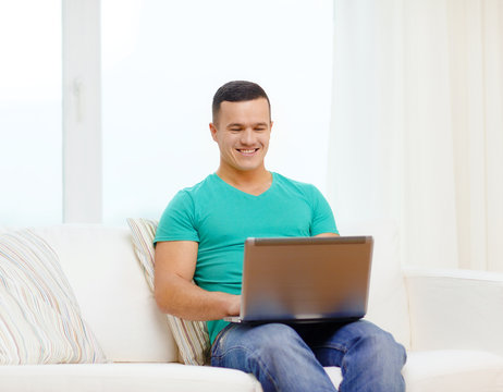smiling man working with laptop at home