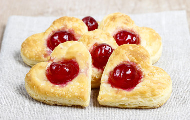 Puff pastry cookies in heart shape filled with cherries