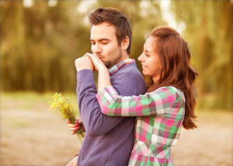 Fototapeta premium Young couple in love walking in the autumn park near the river.