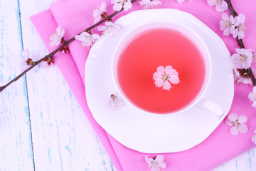 Fragrant tea with flowering branches on wooden table close-up