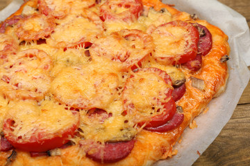 Homemade pizza on baking paper close up