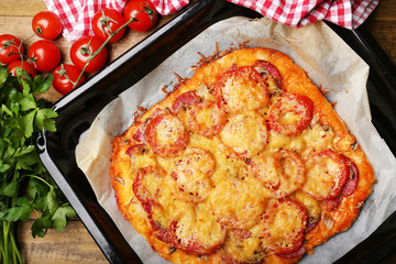 Homemade pizza on baking paper close up