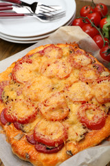 Homemade pizza on baking paper close up