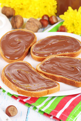 Bread with sweet chocolate hazelnut spread on plate on table