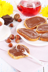 Bread with sweet chocolate hazelnut spread on plate on table
