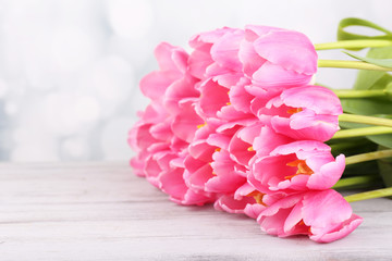 Obraz na płótnie Canvas Beautiful pink tulips on wooden table