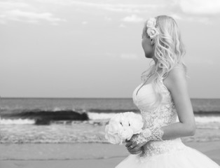 Fototapeta na wymiar Bride on the beach. Unrecognizable young woman in wedding dress