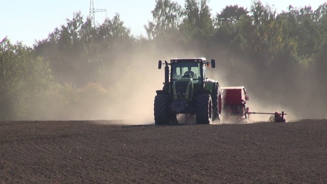 tractor seeding grain crop on farm field