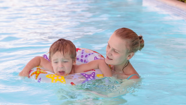 Mother and son swimming in the pool