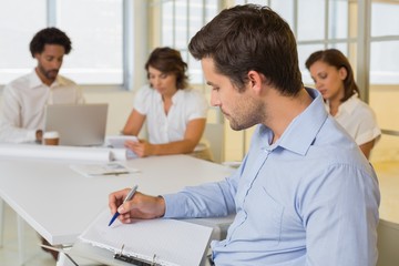 Obraz premium Businessman reading document with colleagues in meeting at offic