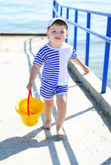 a little boy playing on the sea-shore in summer