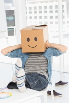 Casual man with happy smiley box over face at office