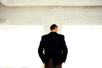 Back view portrait of a businessman standing in office