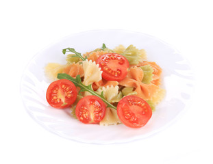 colored farfalle with tomatoes on white plate