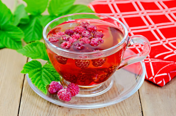 Tea with raspberry and a napkin on board
