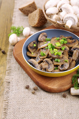 Delicious fried mushrooms in pan on table close-up