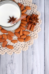 Almond milk in jug with almonds in bowl,