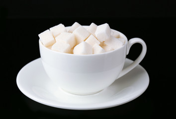 Sugar in cup isolated on black