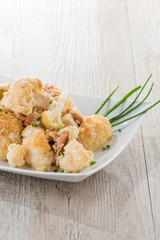 Cavolfiore gratinato con tonno servito su un piatto  bianco